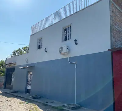 a white building with two windows on the side of it at Habitación cerca del aeropuerto #2 in La Paz