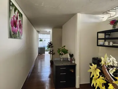 a hallway with a table and flowers on the wall at Gywel in San Salvador