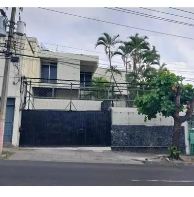 a building with a fence and a tree in front of it at Gywel in San Salvador