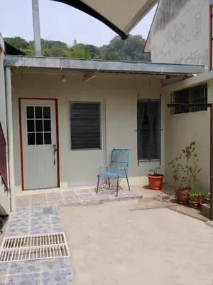 a blue chair sitting in front of a house at Queen Bed in San Salvador