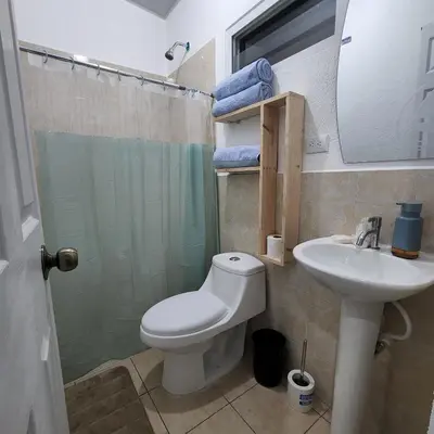 a bathroom with a toilet and a sink and a shower at Santa Ana Maquilishuat in Santa Ana