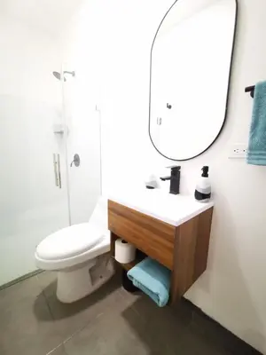 a bathroom with a sink and a toilet and a mirror at Suite privada de 1 habitacion en San Salvador in San Salvador