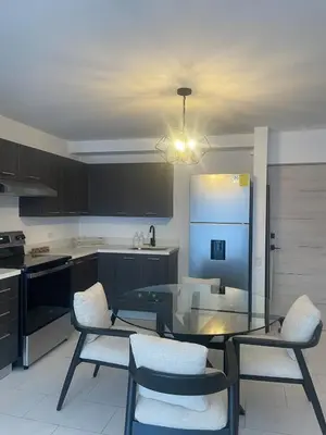a kitchen with a glass table with chairs and a refrigerator at Moderno apart en Col Escalón,vista,piscina,gimnasio in San Salvador