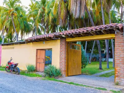 a small house with a motorcycle parked in front of it at Casa DUNA 2 in La Libertad