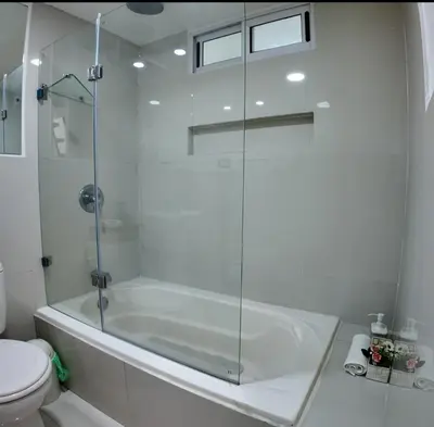 a white bathroom with a tub and a toilet at Las Terrazas Suites Studio Apartment in San Salvador