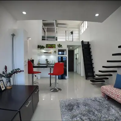 a living room with a desk and red chairs at Las Terrazas Suites Studio-type apartment in San Salvador
