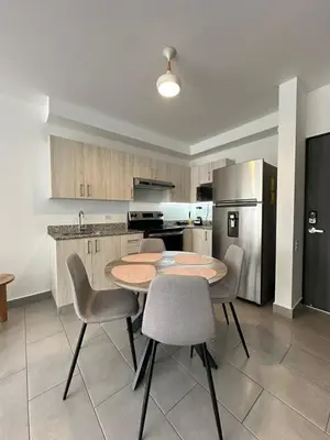 a kitchen with a table and chairs and a refrigerator at Apartamento amueblado Condado Santa Rosa Santa Tecla La Libertad in Nanastepeque
