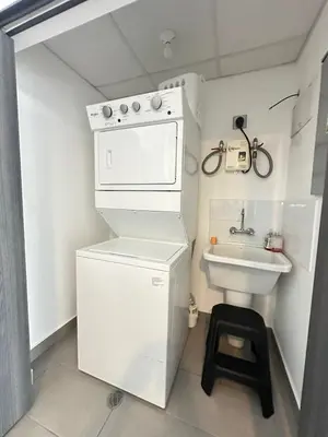 a small white kitchen with a sink and a stove at Apartamento Casas del Árbol Condado Santa Rosa Santa Tecla in Nanastepeque