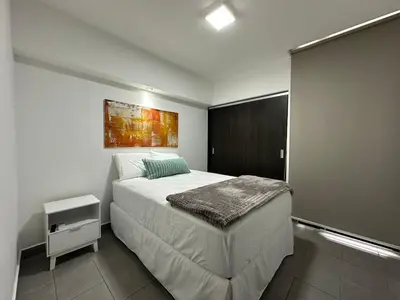 a bedroom with a bed and a painting on the wall at Apartamento Casas del Árbol Condado Santa Rosa Santa Tecla in Nanastepeque