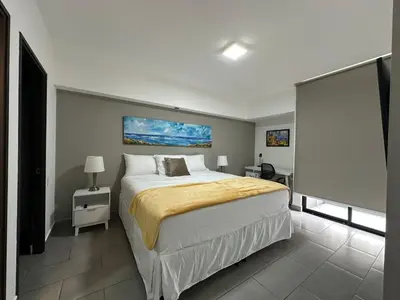 a bedroom with a large bed in a room at Apartamento Casas del Árbol Condado Santa Rosa Santa Tecla in Nanastepeque