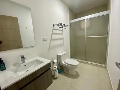 a bathroom with a sink and a toilet and a mirror at Luxury Apartment in San Salvador in San Salvador