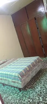 a bed in a bedroom with a wooden cabinet at Casa San Fernando, Ahuachapan in Ahuachapán