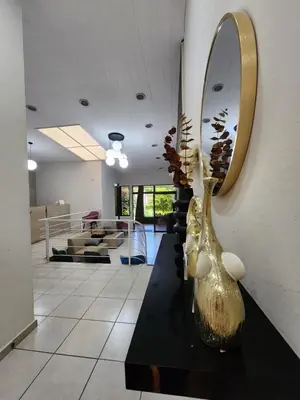 a lobby with a mirror and vases on a table at La Mochila Urbana2 in San Salvador