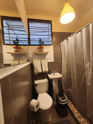 a bathroom with a toilet and a sink at La Mochila Urbana3 in San Salvador