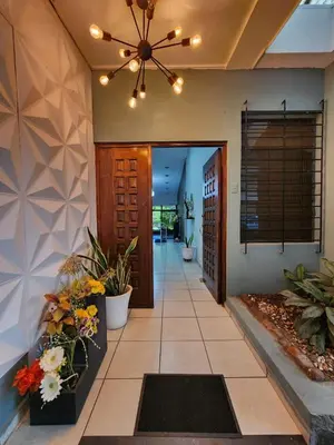 a hallway of a home with a ceiling fan and flowers at Mochila Urbana6 in San Salvador