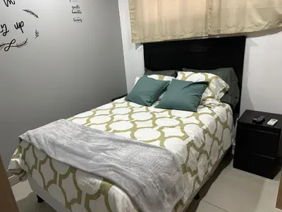 a bedroom with a bed with blue pillows at Luxury Apartment -The Flats in San Salvador