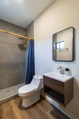 a bathroom with a toilet and a sink and a mirror at 2 Bedroom Apartment with full beds and bunk beds in El Zonte