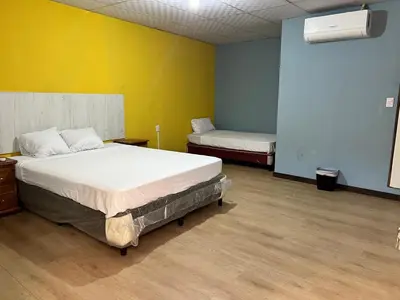 a bedroom with two beds and a yellow wall at Noche de Luna in San Salvador