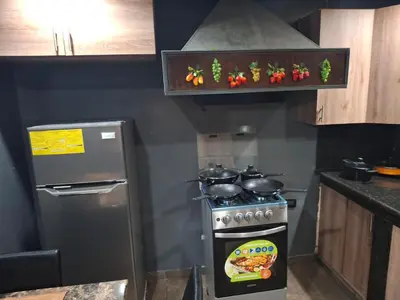 a kitchen with a stove and a refrigerator at Alquileres El Ángel in San Salvador