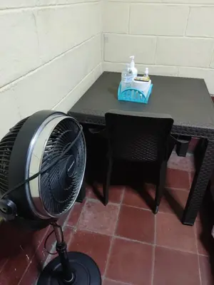 a table with a fan in front of a table with a tableablish at Kame-House Backpackers in San Salvador