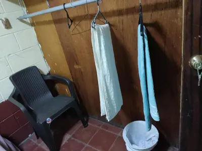 a bathroom with a toilet and a chair in it at Kame-House Backpackers in San Salvador