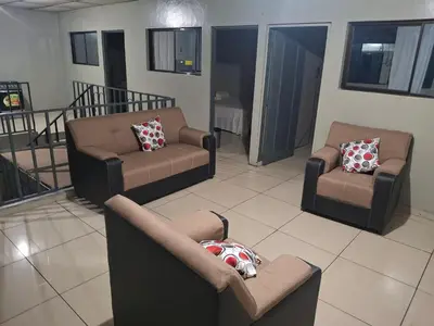 a living room with couches and chairs in a room at Habitación sencilla in San Salvador