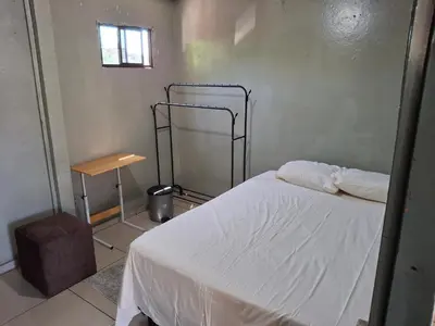 a bedroom with a white bed and a table at Habitación sencilla in San Salvador