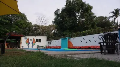 a wall with birds on it next to a building at Rancho Los Hernandez - Surf City - El Tunco in Tamanique