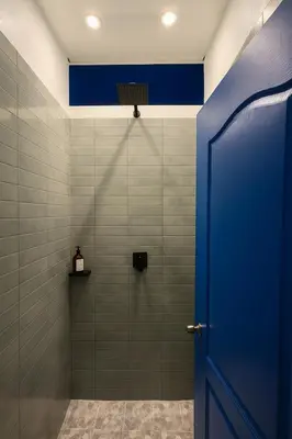 a bathroom with a shower with a blue door at Surfside El Tunco in Tamanique