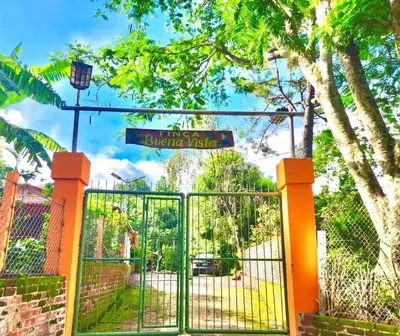 a gate with a street sign on top of it at Cozy Bedroom in a coffee farmn in Coatepeque Lake in Santa Ana