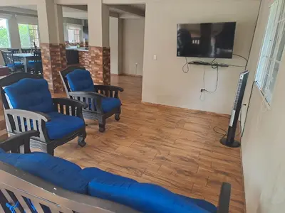 a waiting room with blue chairs and a flat screen tv at Rancho número 50 in La Libertad