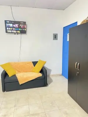 a room with a couch with yellow pillows on it at La ceiba surf in El Sunzal