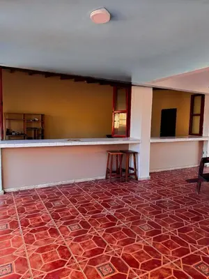 an empty room with a red tile floor and a bar at Villa Vallarta Costa del Sol in Marcelino