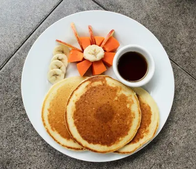 a white plate with pancakes and a cup of coffee at Hostal Casa del Sol Apartamento in Suchitoto