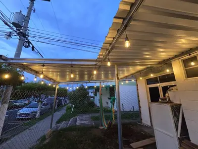 a pergola with lights on the side of a house at the best private apartmet in santa ana for your trip with excelente location in Santa Ana