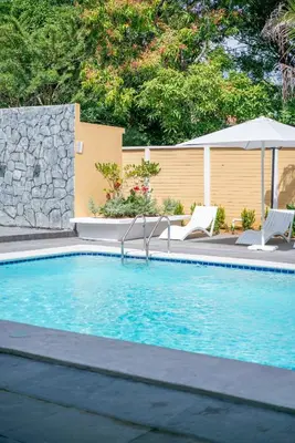a swimming pool with two chairs and an umbrella at Suite sencilla
