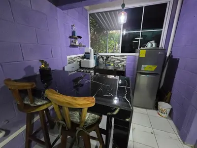 a purple kitchen with a counter and two chairs at central and private apartment in Santa Ana