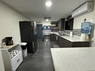 a kitchen with a refrigerator and a counter in it at Pool • Game Room • Fire Pit • Resort Access in Los Cóbanos