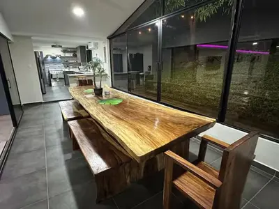 a large wooden table in a room with a large window at Game Room • Fire Pit • Pool • Resort Access in Los Cóbanos