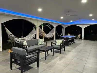 a living room with a couch and a ping pong table at Pool • Resort Access • Game Room • Fire Pit in Los Cóbanos