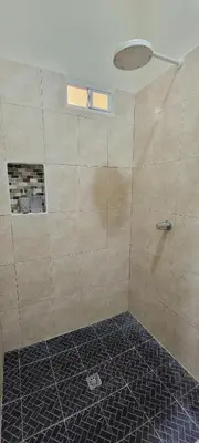 a bathroom with a shower with a tiled floor at habitacion costabay in San Luis La Herradura