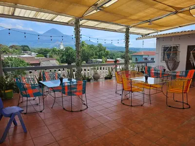a patio with colorful chairs and tables on a balcony at El hostal de Uriel in Izalco