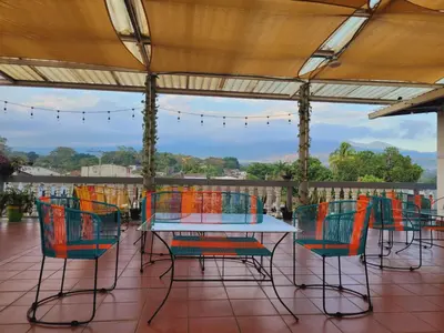 a table and chairs on a patio with a view at El hostal de Uriel in Izalco