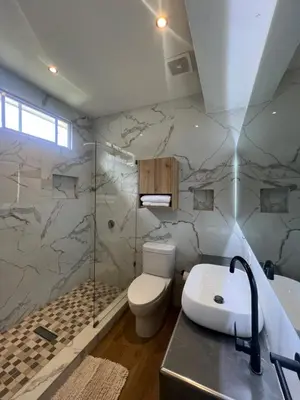 a bathroom with a toilet and a shower and a sink at Villa Napoli Apartment Suites in Santa Ana