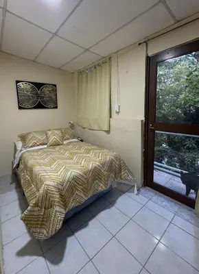 a bedroom with a bed and a window at Habitacion con aire acondicionado in San Salvador