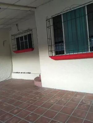 a corner of a building with two windows and a brick floor at Habitacion con aire acondicionado in San Salvador