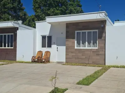a house with two chairs in front of it at Casa Chaparrastique in San Miguel