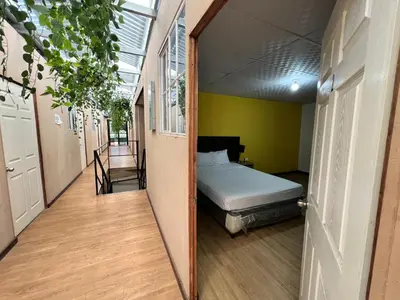 a bedroom with a bed in a room with a hallway at Hostal Noche de Luna in San Salvador