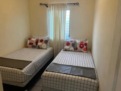 two twin beds in a room with a window at A 5 minutos de las Ruinas del Tazumal, Chalchuapa Santa Ana El Salvador in Chalchuapa