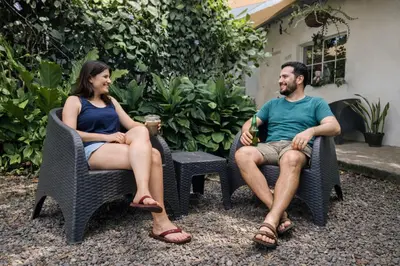 a man and a woman sitting in chairs at Habitación Agua - Villa Valle Campo in Nahuizalco